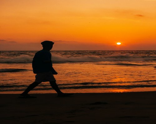 Man walking by the sea at sunset for relaxation